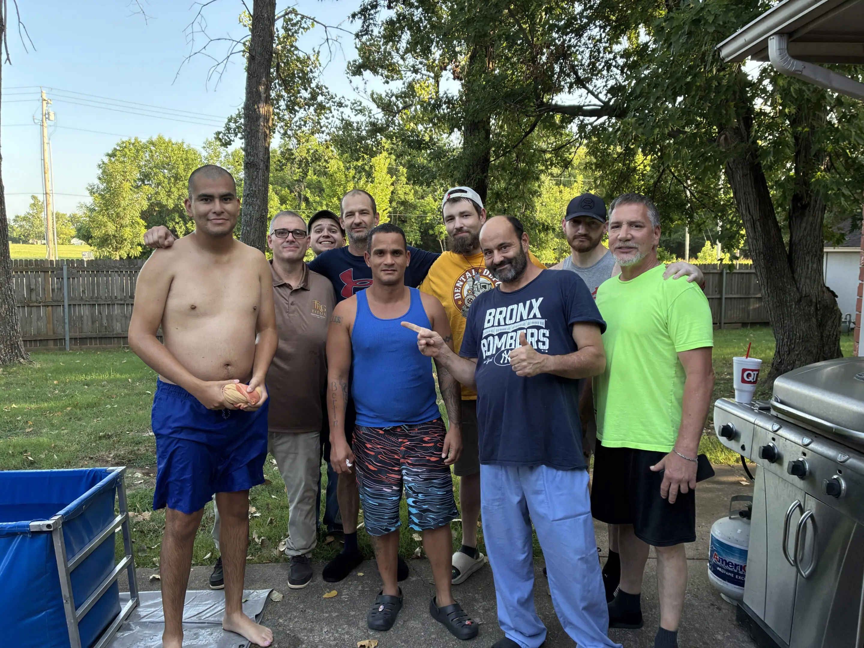 Friends gathering near a backyard grill