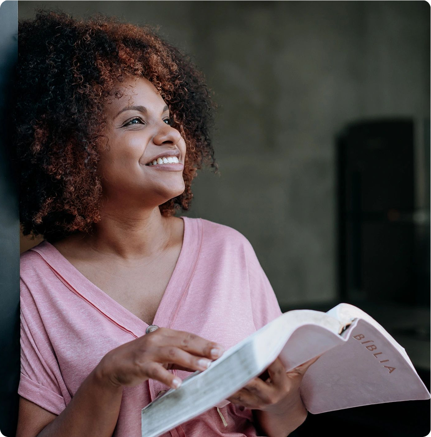 Smiling woman holding an open book.